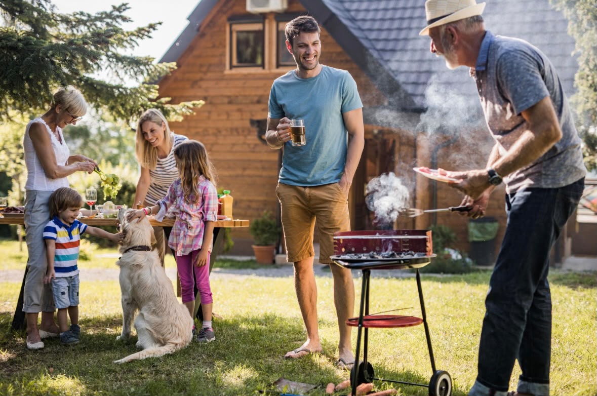 Famille profitant de sa cour arrière autour d’un barbecue avec son chien